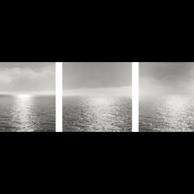 Three black-and-white photographs of sunlight breaking through fog over calm, glittering water, each panel showing the light band shifting position across the horizon.