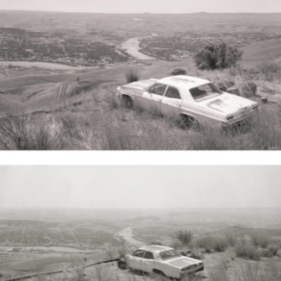 Diptych, the same view from a bluff over a river town: a white sedan wreck angled downhill above the valley in the upper photograph, and the same scene reframed tighter and lower in the photograph below it, with the car closer to the foreground.