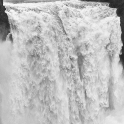Black-and-white photograph of an artificial tiered waterfall cascading over rockwork beside a resort pool, the CasaBlanca Resort Casino sign and palm trees visible in the distance.